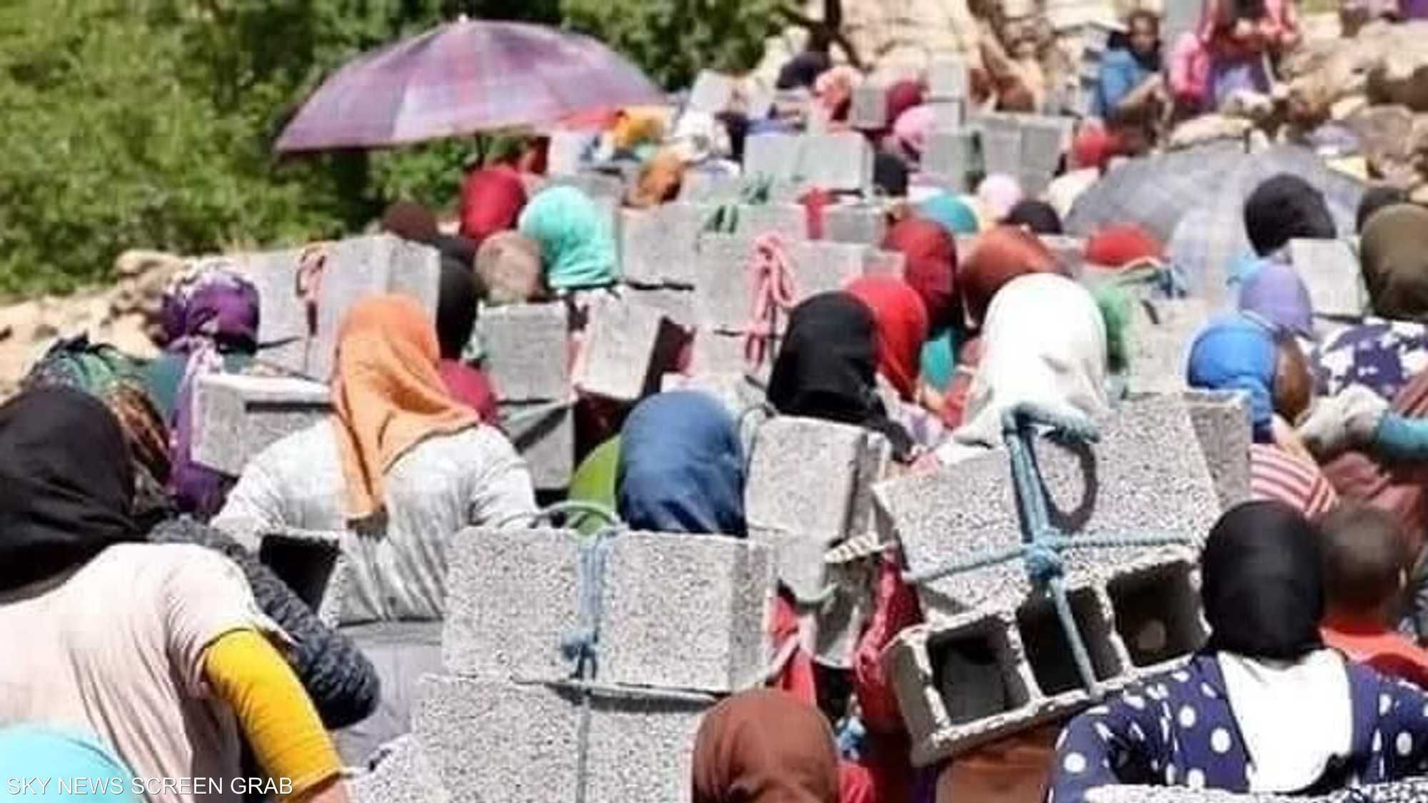 نساء أطلس المغربي يحملن كتل الخرسانة